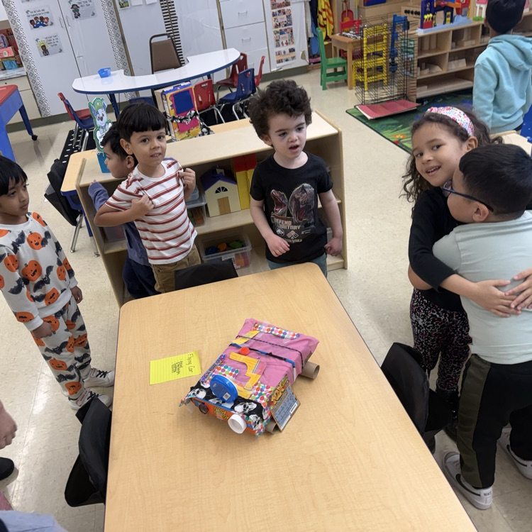 Students in a classroom looking at projects