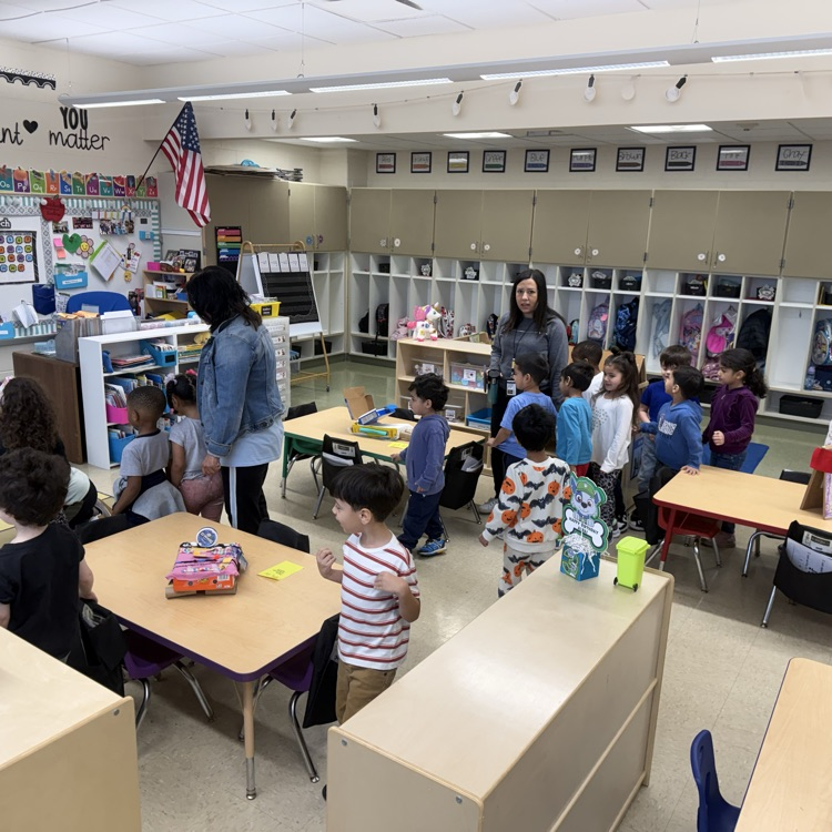 Students in a classroom looking at projects