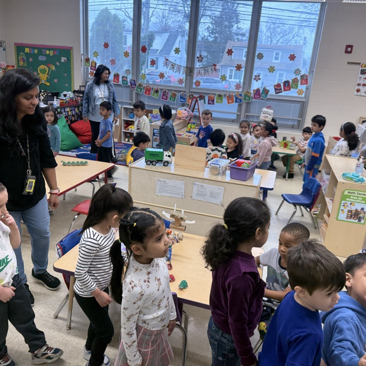 Students in a classroom looking at projects