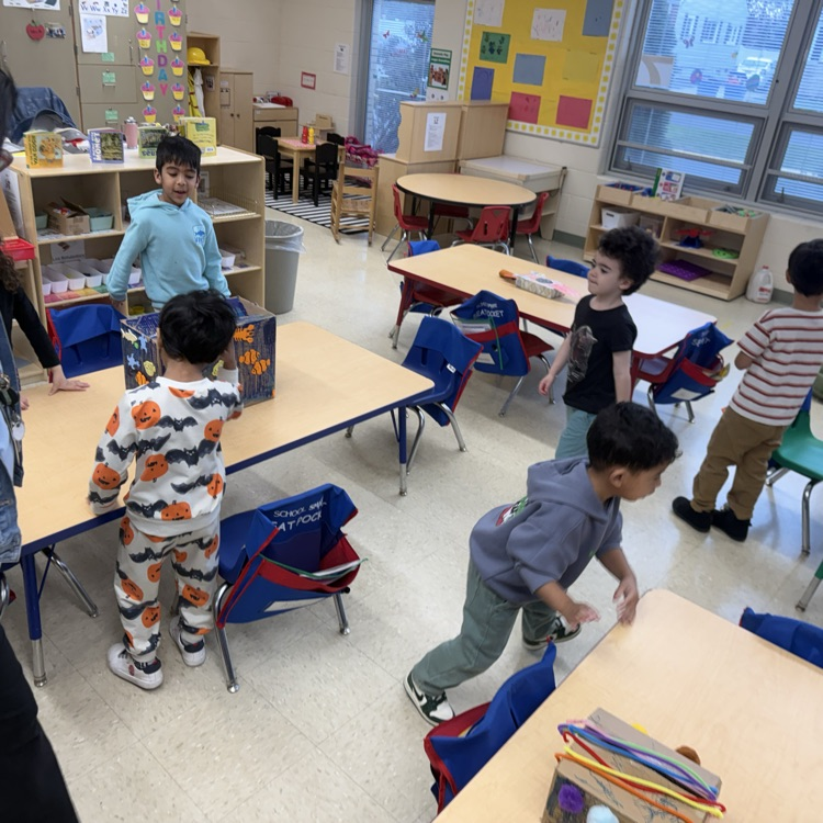 Students in a classroom looking at projects