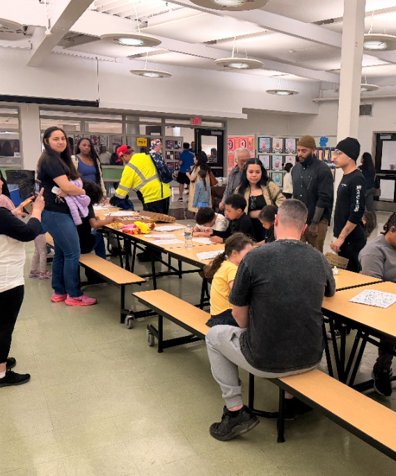 Parents and students doing crafts at a long table