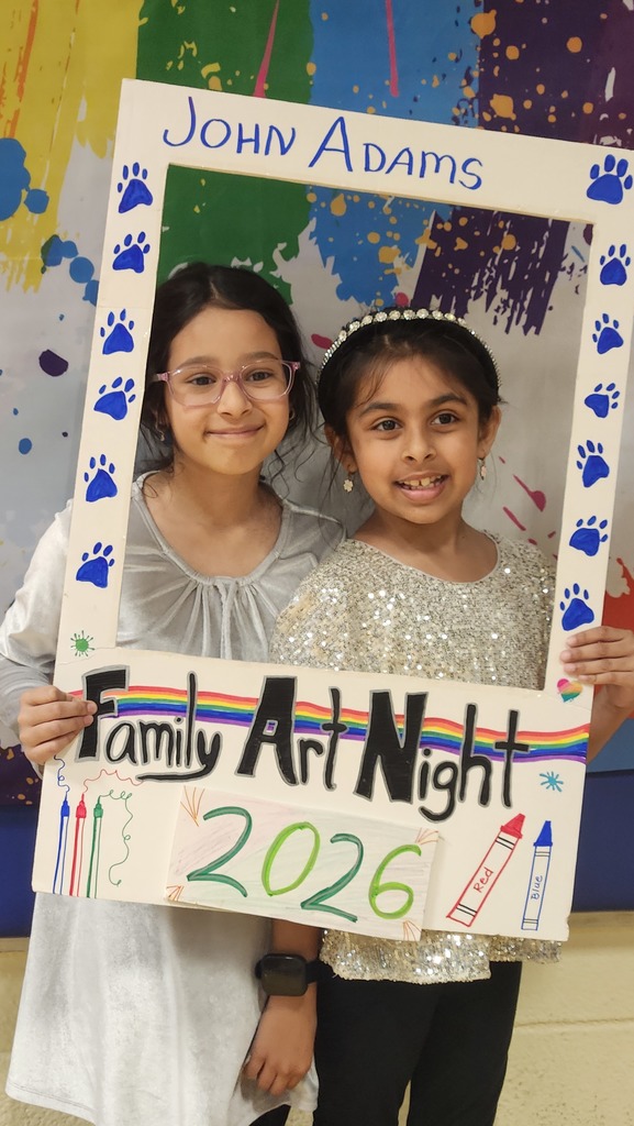 Students posing in a sign that says art night 2026