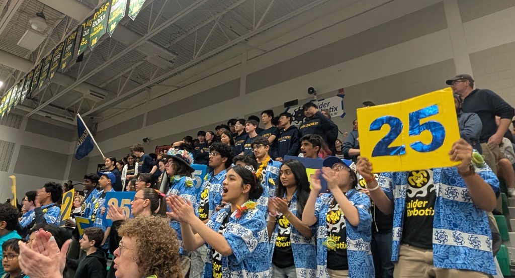 The Raider Robotix team cheering on their team as they compete in the playoffs.