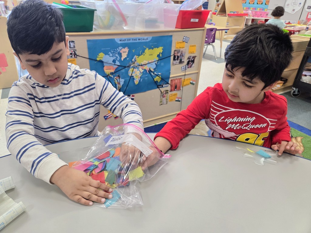 Students making puzzle pieces at a table