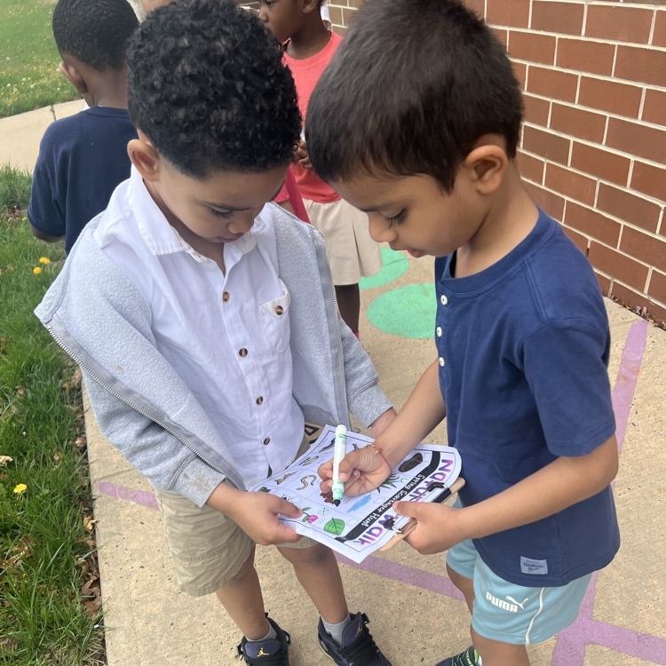 Students marking off a paper scavenge hunt about nature