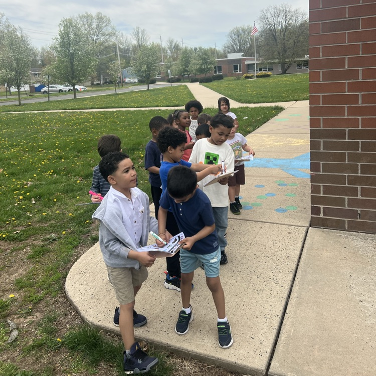 Students marking off a paper scavenge hunt about nature