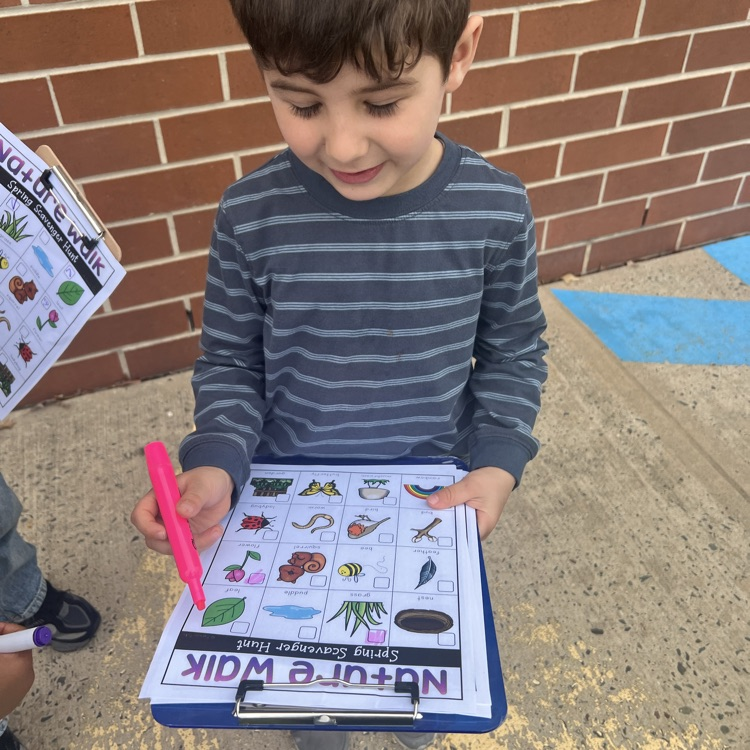 Students marking off a paper scavenge hunt about nature