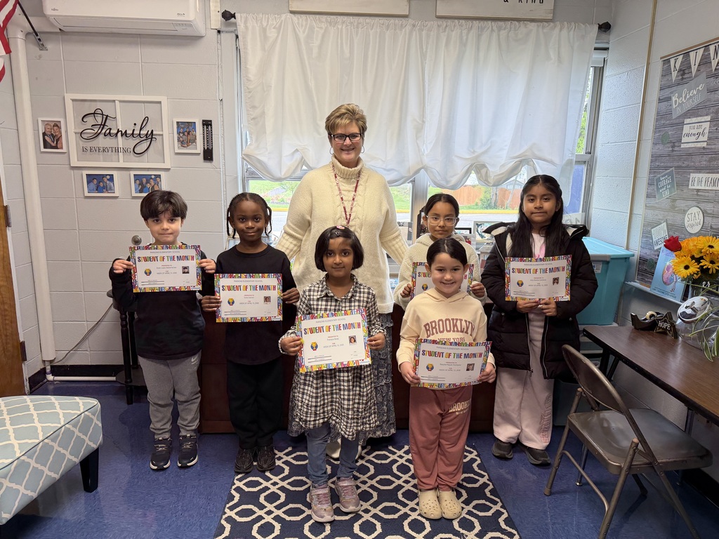Students holding certificates posing with their  principal