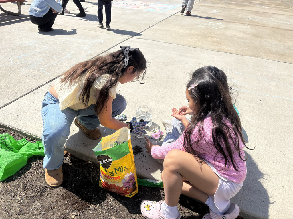 Student Council members help add dirt to the water bottle planters.