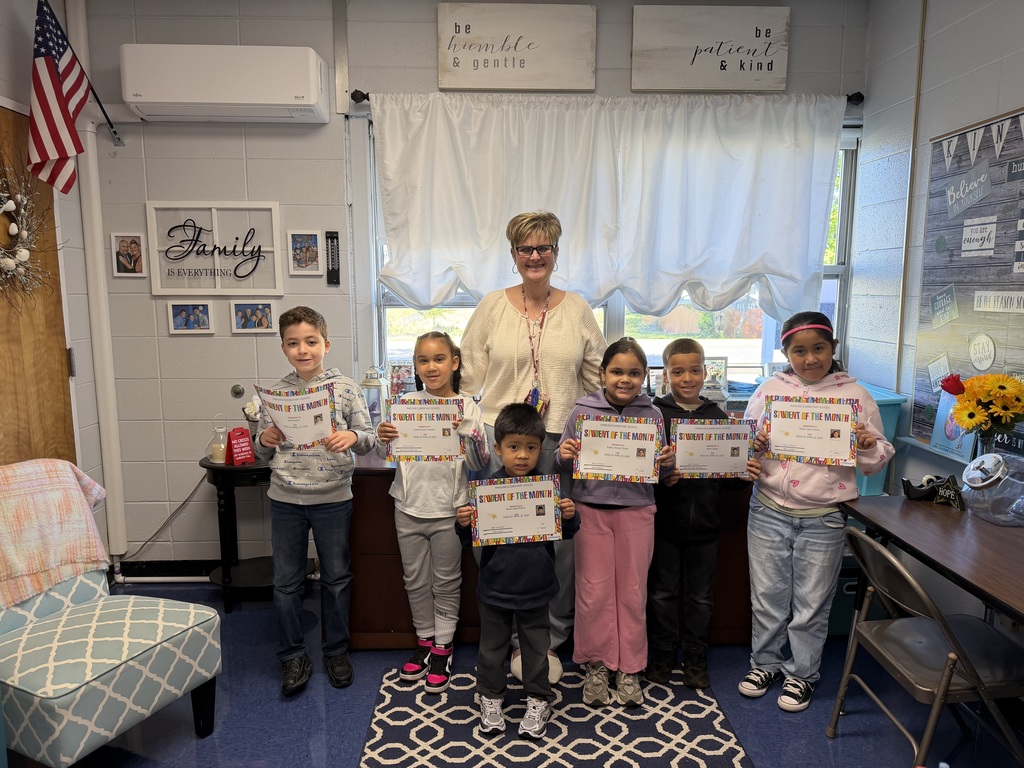 Students holding certificates posing with their  principal