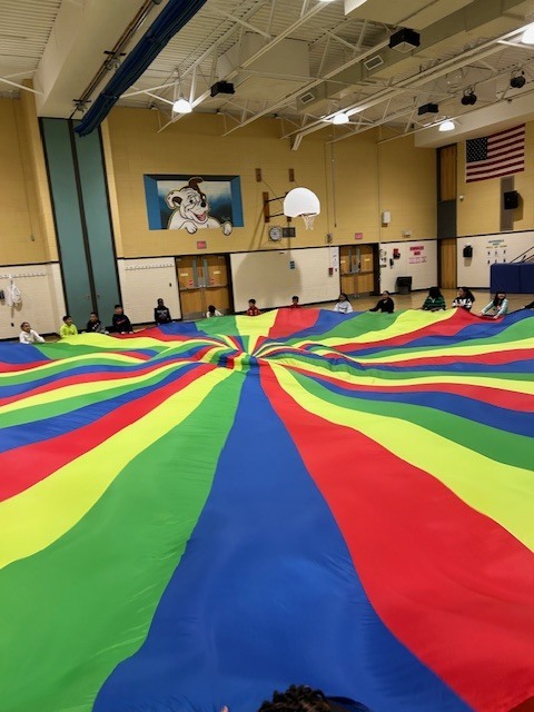 Students playing with large parachute