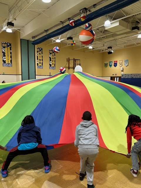 Students playing with large parachute