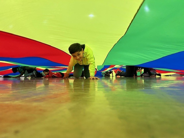 Students playing with large parachute