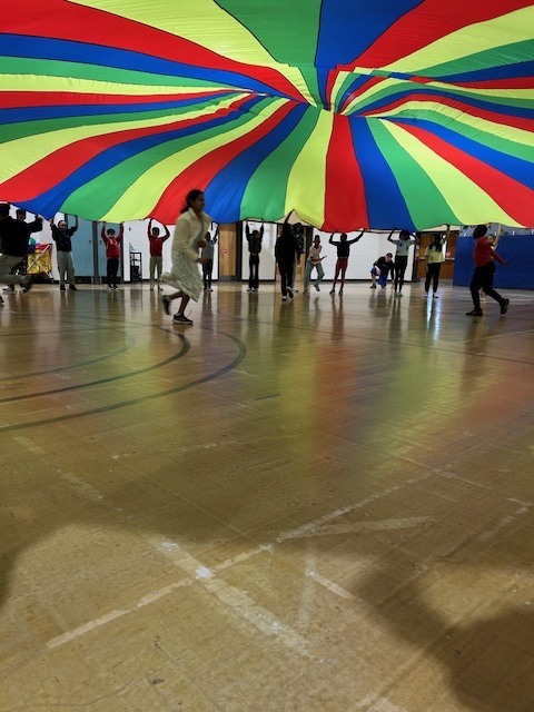 Students playing with large parachute