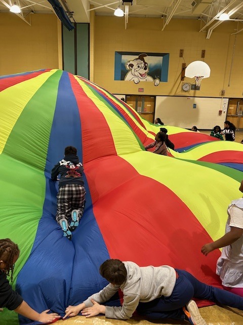 Students playing with large parachute