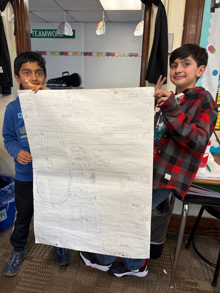 Student holding up a poster drawing of a house