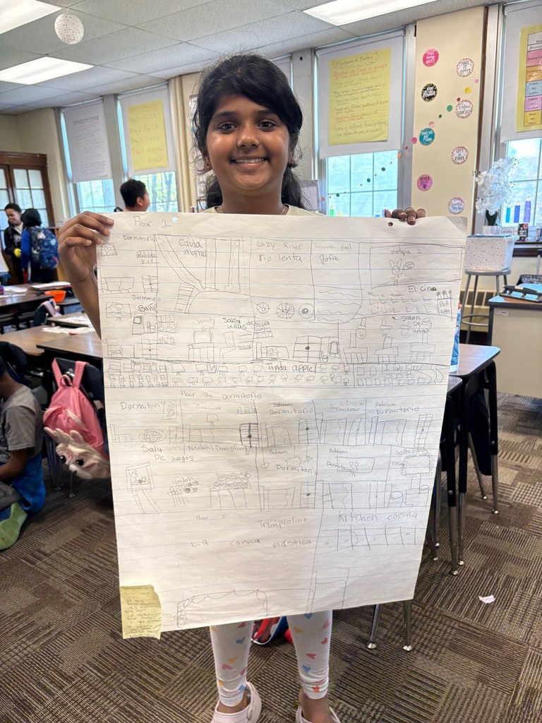 Student holding up a poster drawing of a house