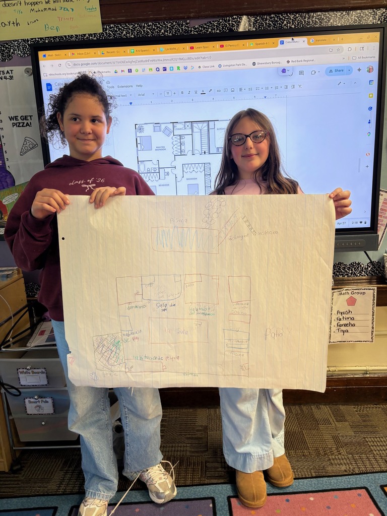 Student holding up a poster drawing of a house