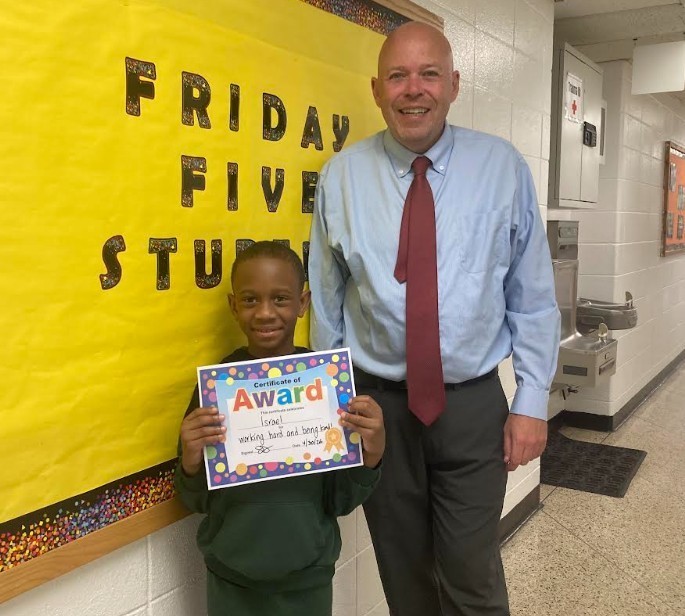Friday Five 5/1/26, student standing with principal