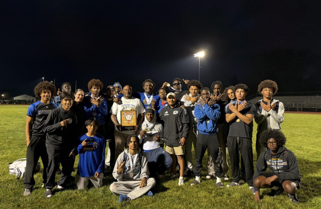 Track athletes posed together on a field
