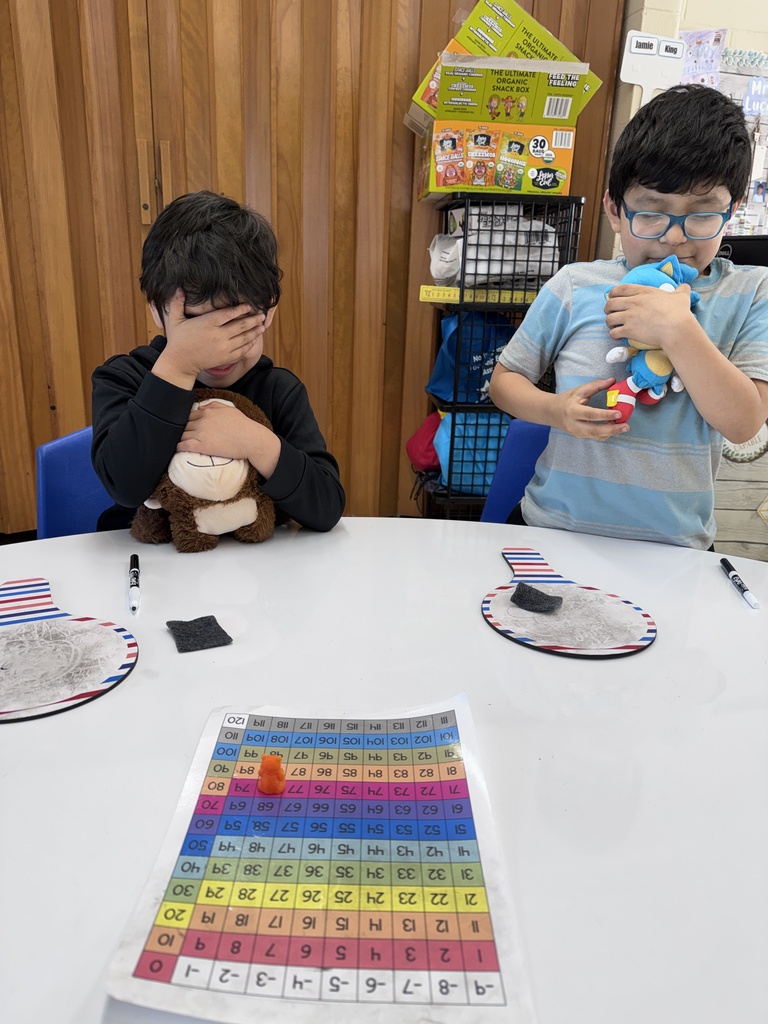 Everyone is closing their eyes while the bear is placed on the number grid.