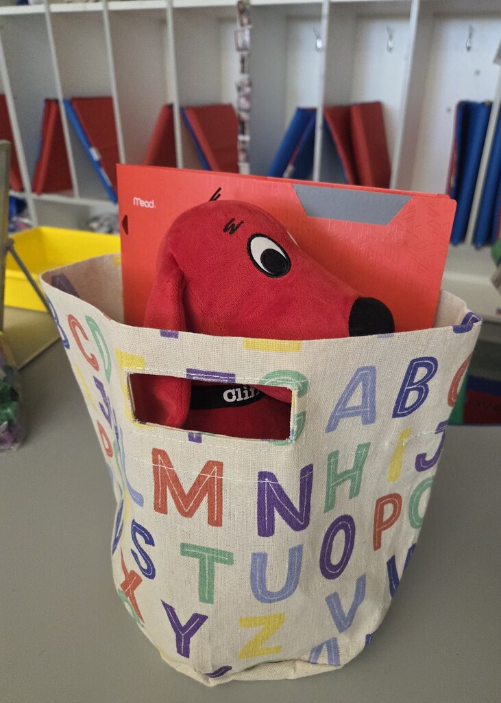 Clifford the red dog sticking out of a bag