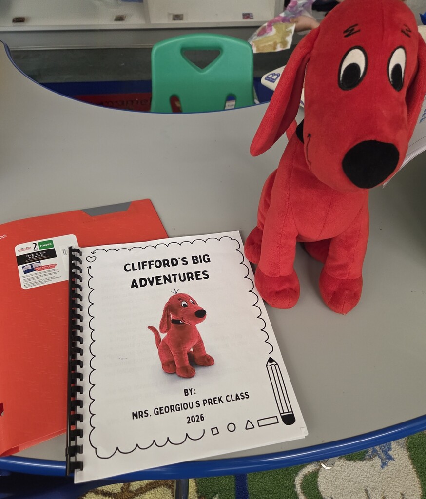 Clifford the red dog stuff animal next to a journal book