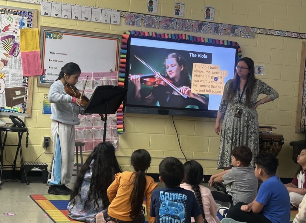4th grade student plays the violin for 2nd grade music class