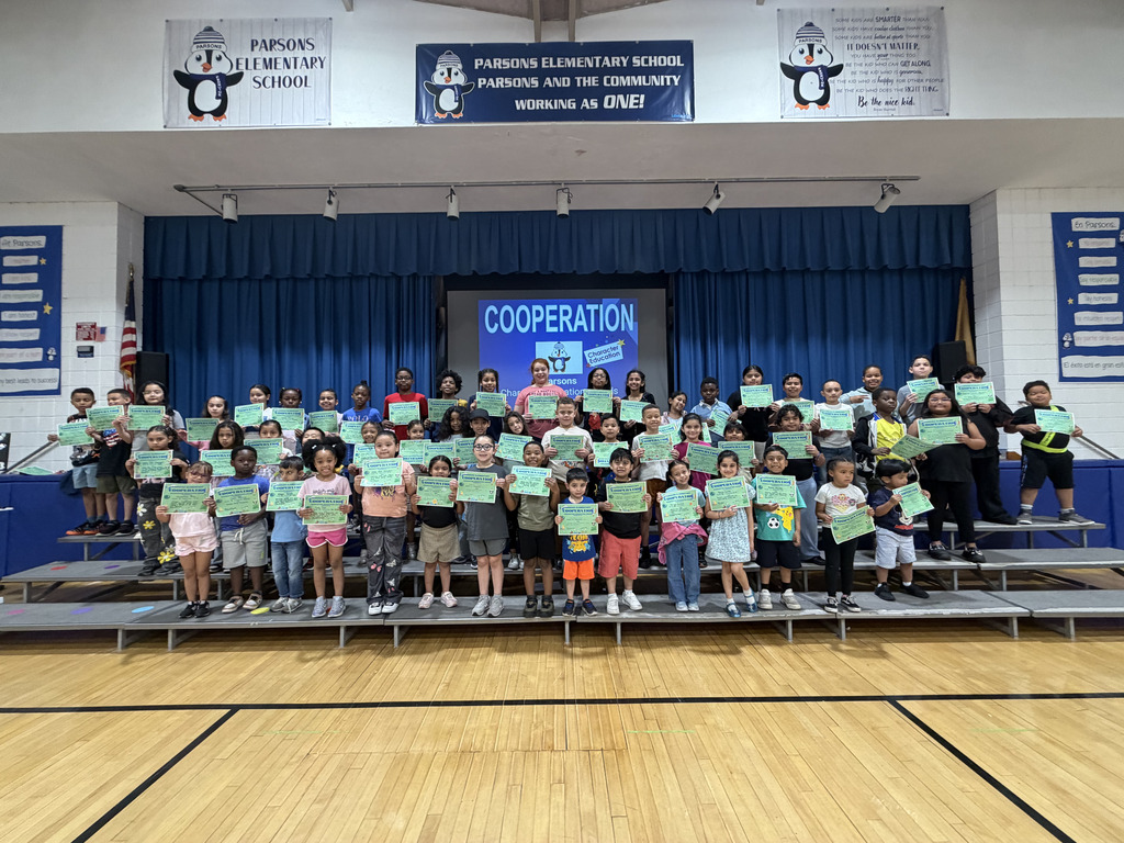 Student assembly of kids holding certificates