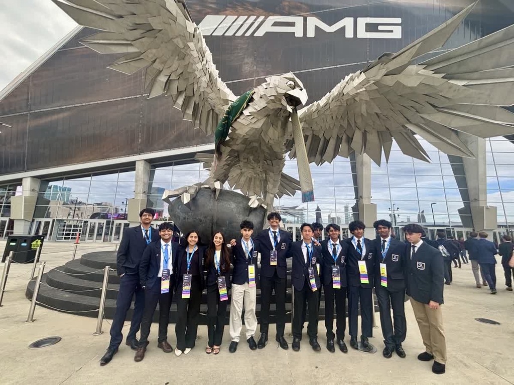 Students pose in front of Atlanta falcons statue