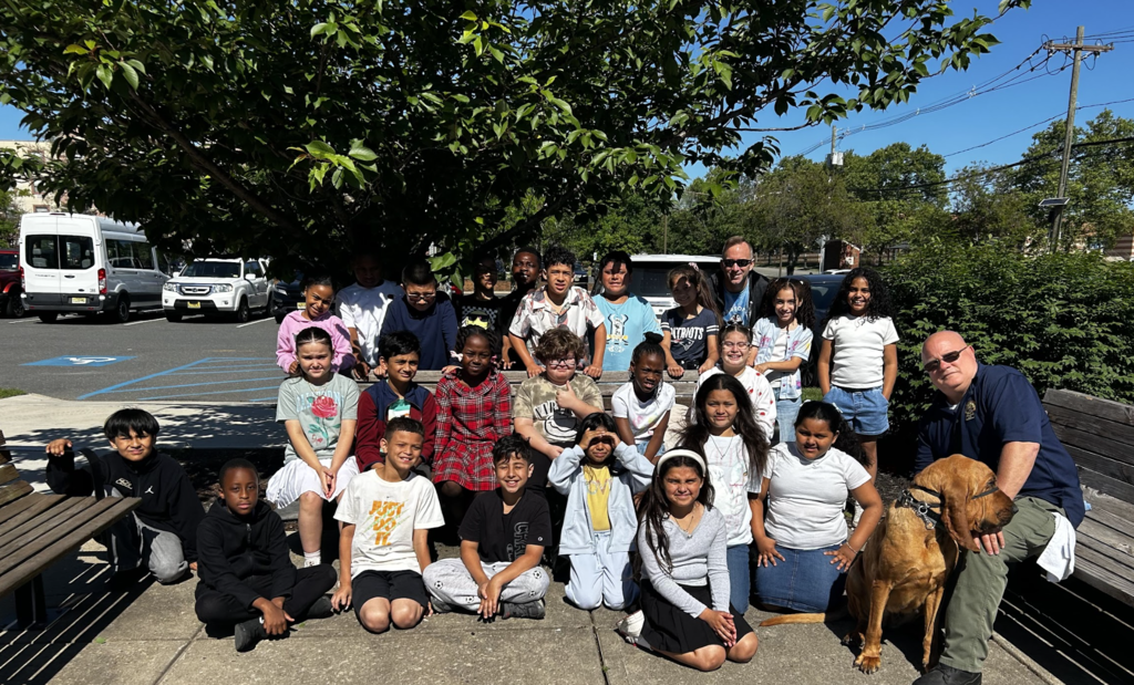 Students posed outside with k-9 & officer