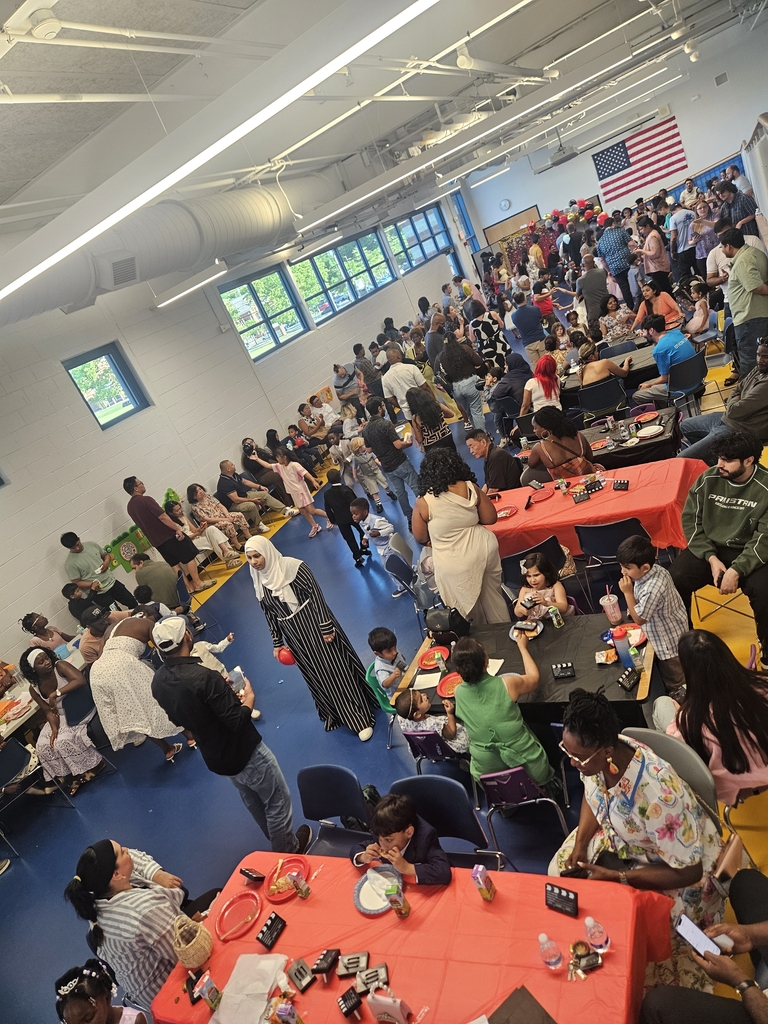 Students and families sitting at tables in school gym