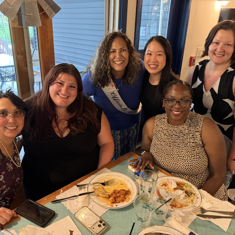Staff posing at a lunch table together