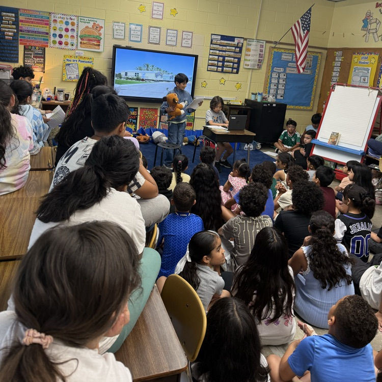 Students in a classroom sitting on the floor