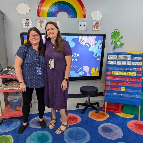 Two teachers posing in their classroom
