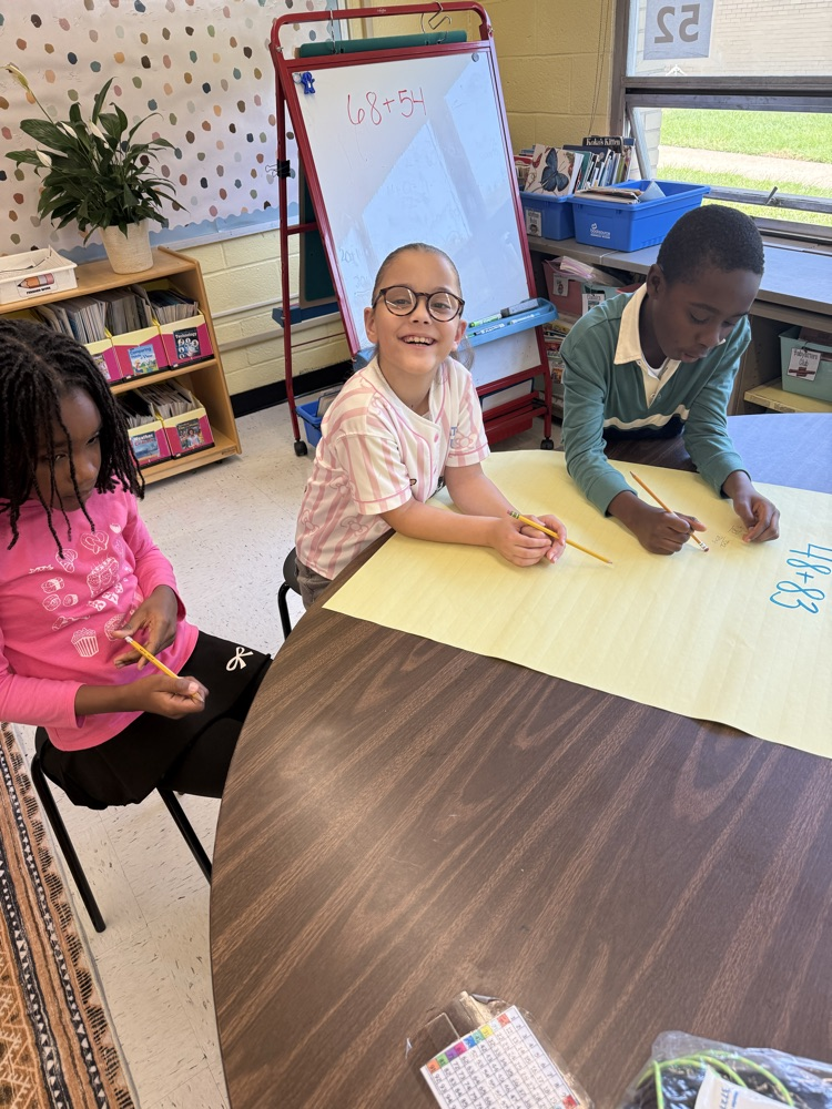 Students working on large posters doing math problems