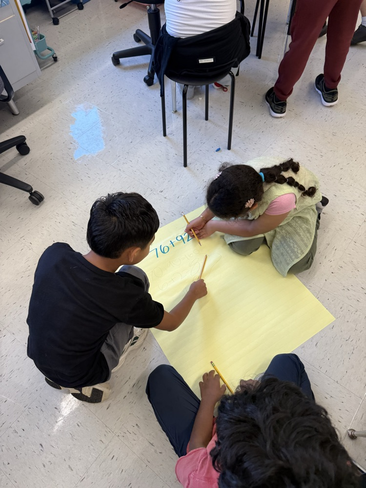 Students working on large posters doing math problems