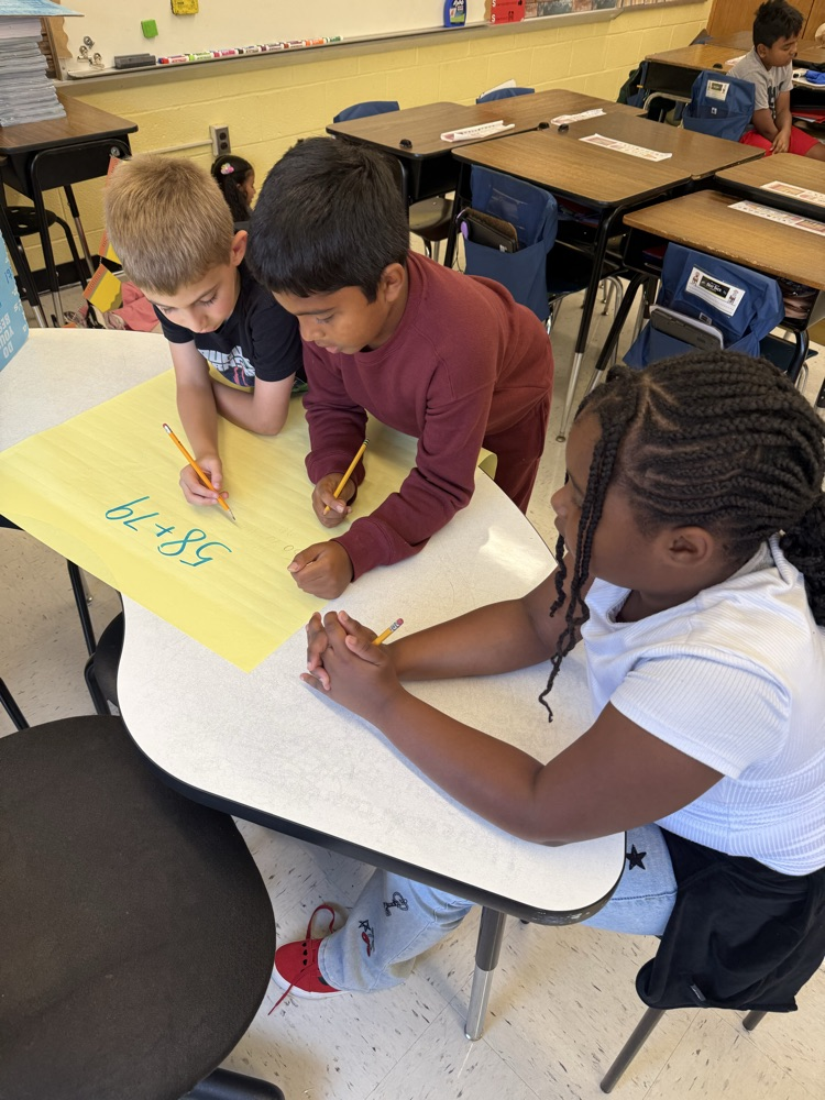 Students working on large posters doing math problems