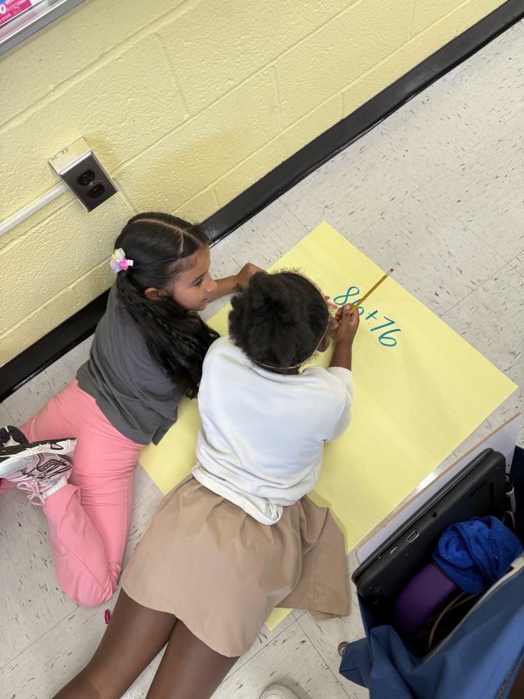 Students working on large posters doing math problems