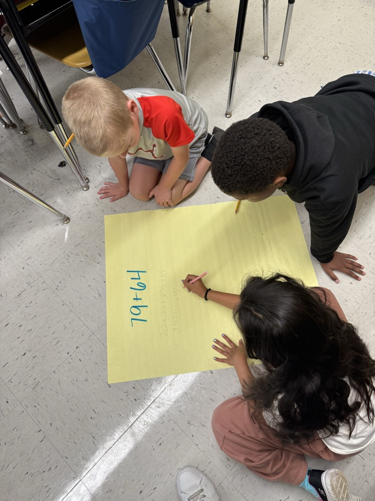 Students working on large posters doing math problems