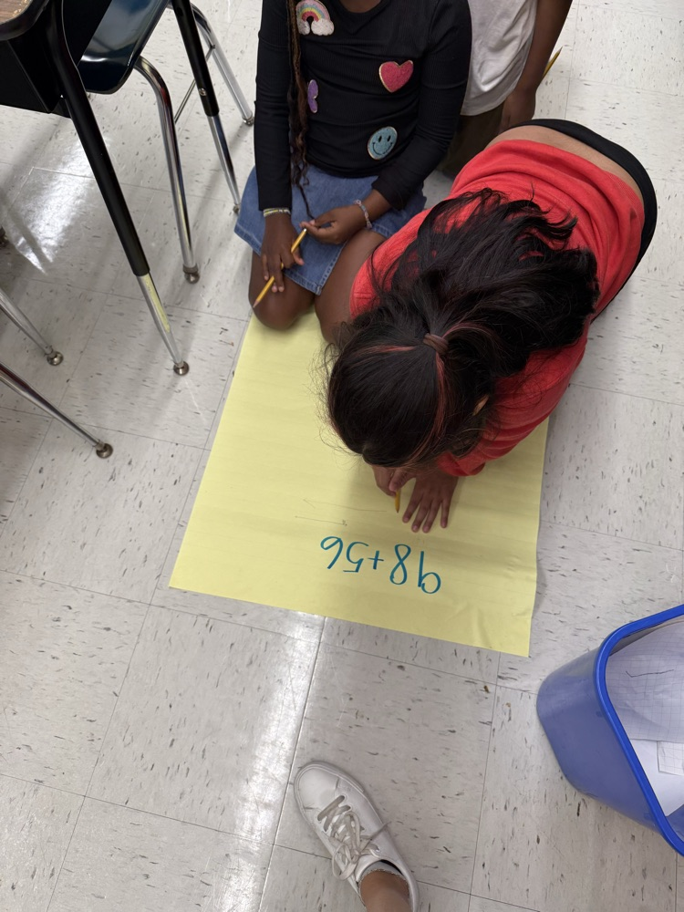 Students working on large posters doing math problems