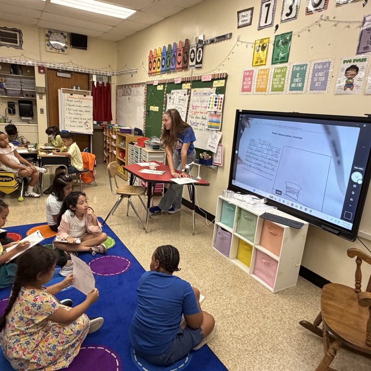 teacher and students reviewing their work 