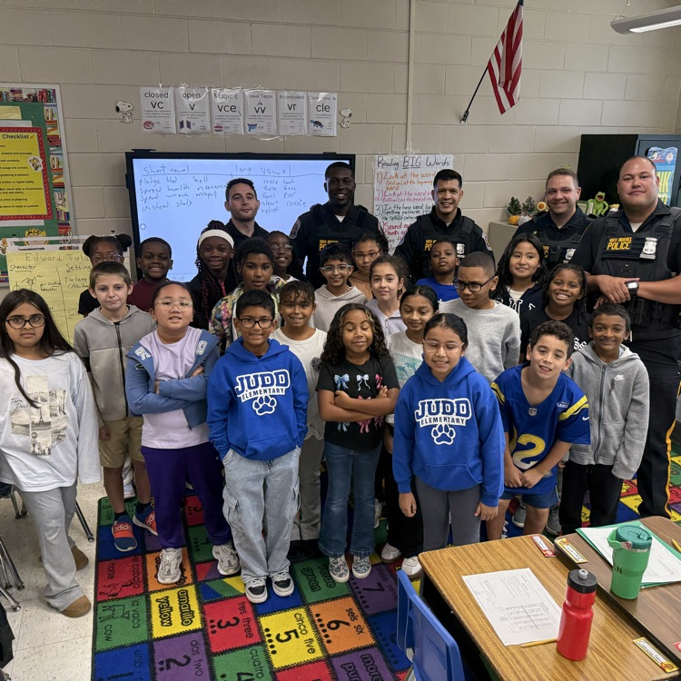 4th graders standing with police officers in group photo
