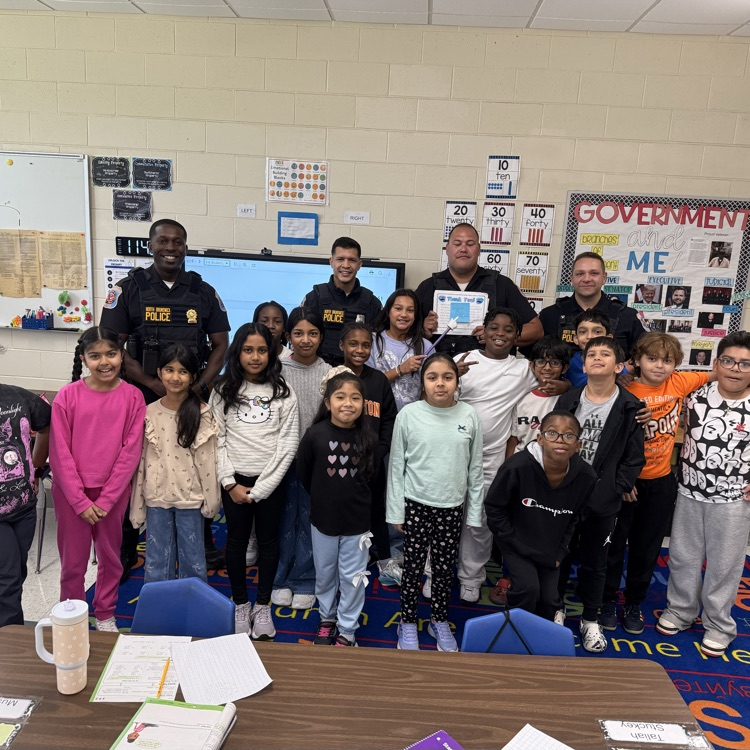 4th graders standing with police officers in group photo