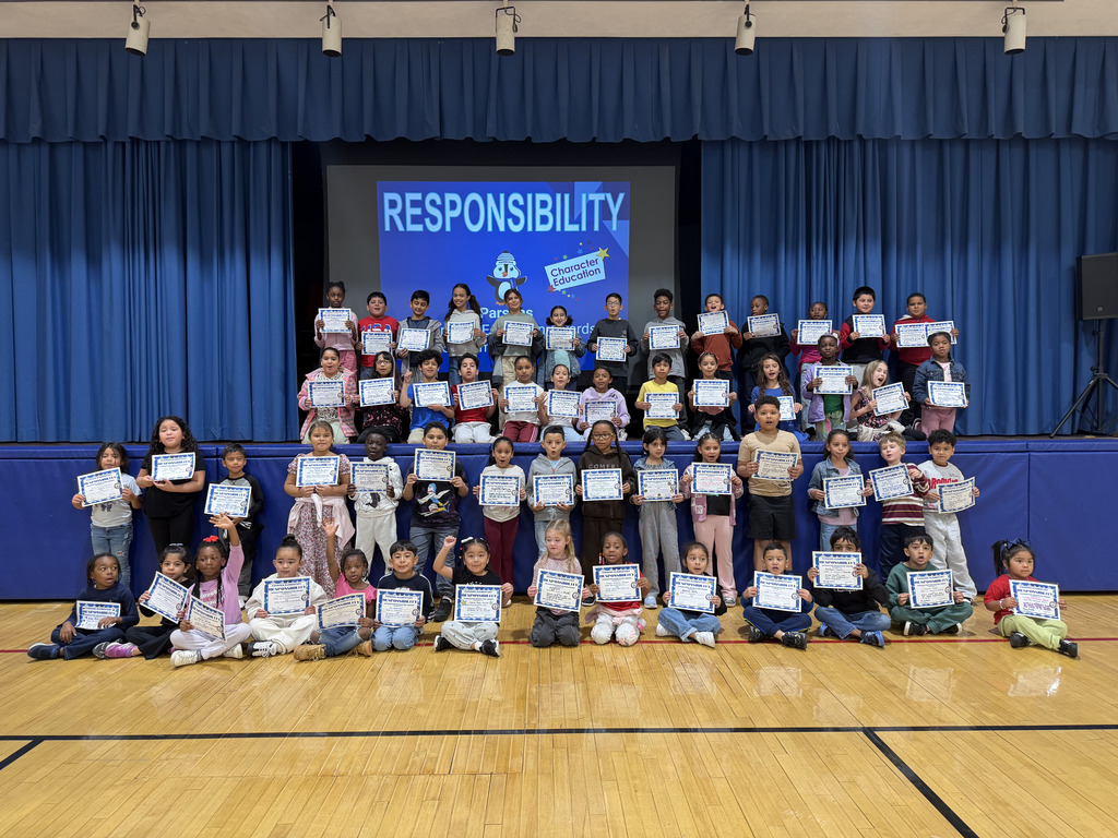 Assembly of students in front of a sign Responsibility