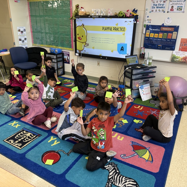 Students in a classroom working on letter identification