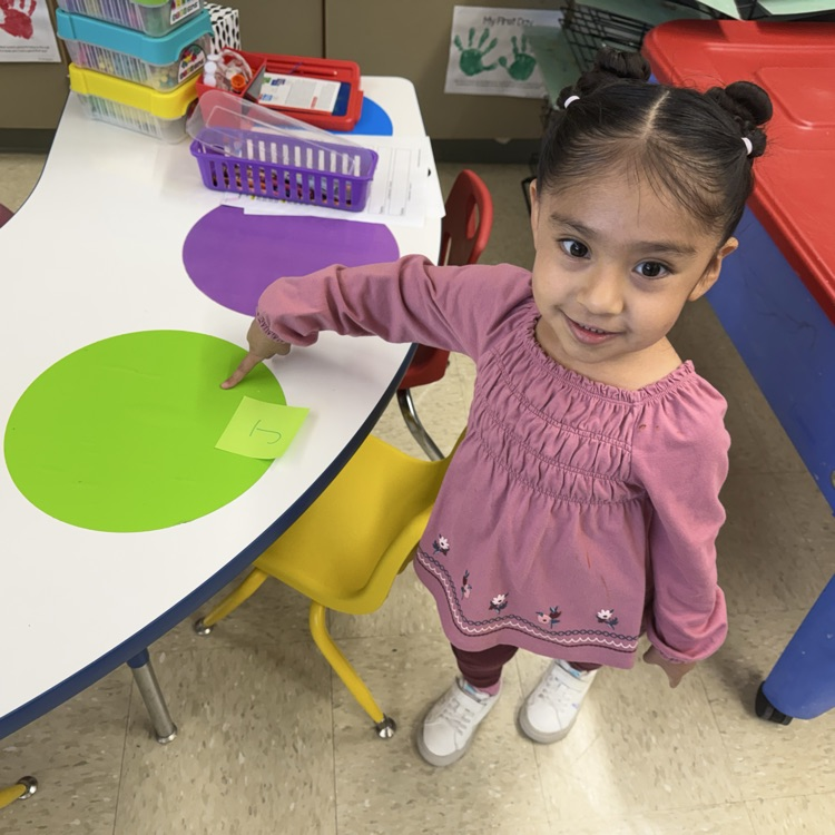 Student pointing to a green placemat