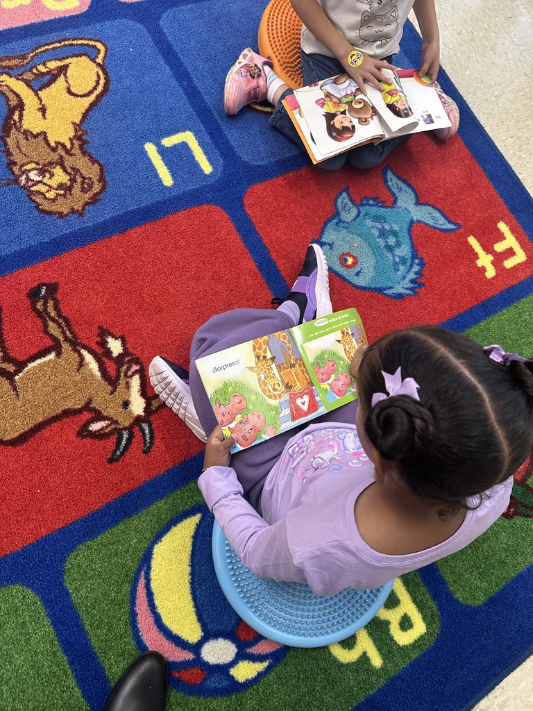 Students reading at library station.