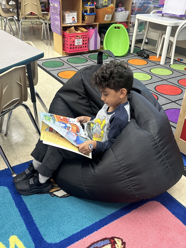 Students reading at library station.