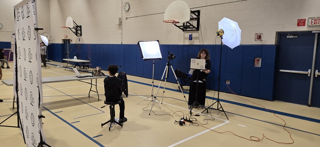 Students waiting to have their photos taken in gym